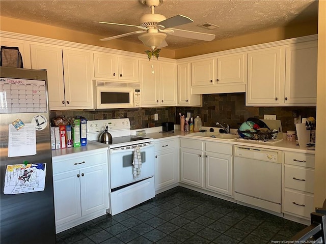 kitchen featuring white appliances, decorative backsplash, light countertops, white cabinetry, and a sink