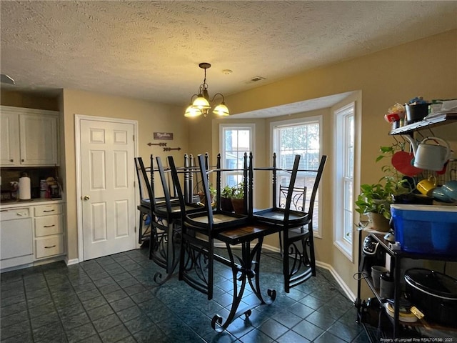 dining area with a textured ceiling, baseboards, and a notable chandelier