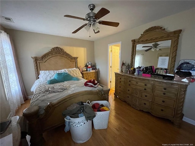 bedroom featuring light wood-type flooring, visible vents, ceiling fan, and baseboards