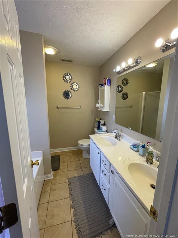 bathroom featuring a stall shower, a sink, visible vents, and tile patterned floors