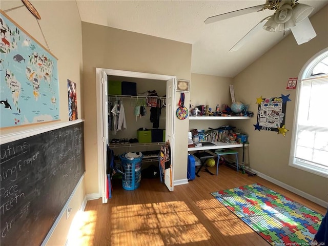 bedroom with baseboards, a ceiling fan, wood finished floors, vaulted ceiling, and a closet