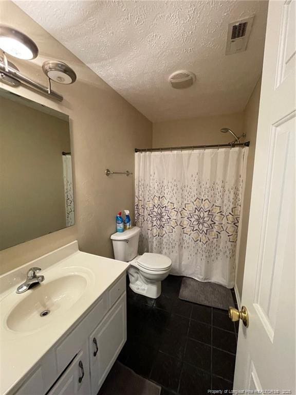 bathroom with visible vents, toilet, a textured ceiling, vanity, and tile patterned floors