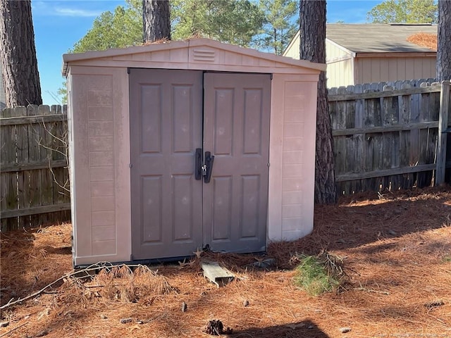 view of shed featuring fence