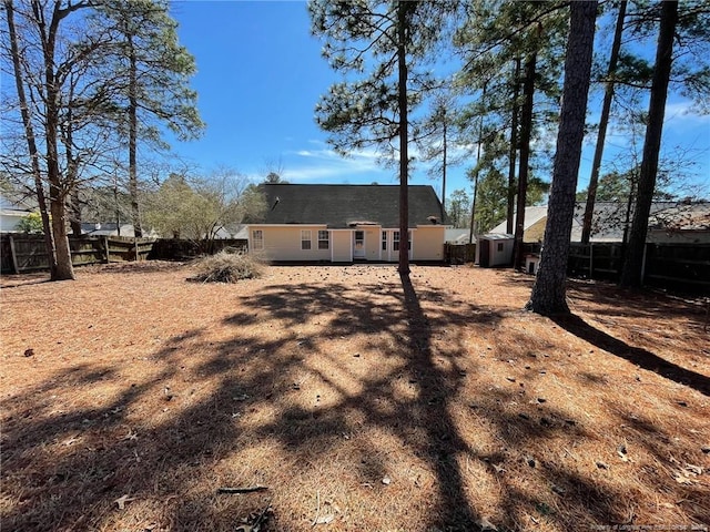 back of house with a fenced backyard and an outdoor structure