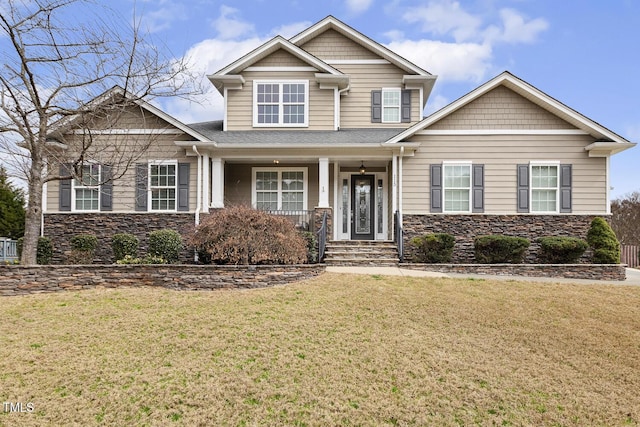 craftsman house with stone siding and a front lawn