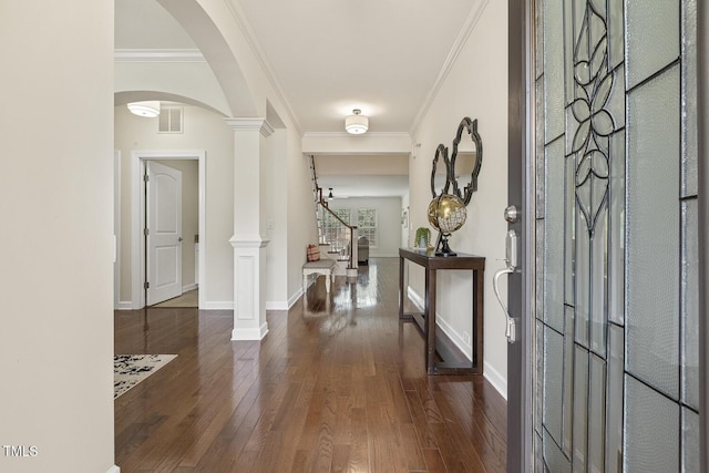 foyer with visible vents, hardwood / wood-style floors, stairway, crown molding, and ornate columns