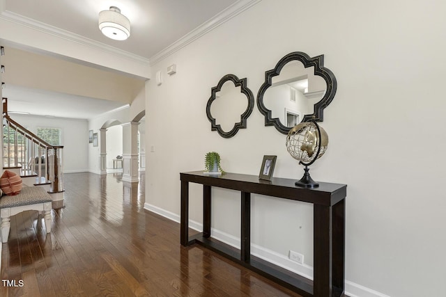 hallway featuring hardwood / wood-style flooring, stairway, crown molding, decorative columns, and baseboards