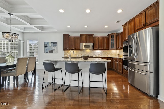 kitchen with a sink, decorative backsplash, dark wood-type flooring, and stainless steel appliances