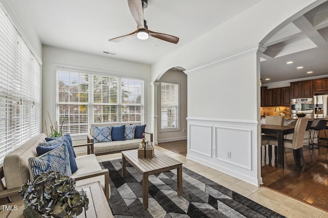 living room featuring visible vents, recessed lighting, arched walkways, a decorative wall, and light tile patterned floors