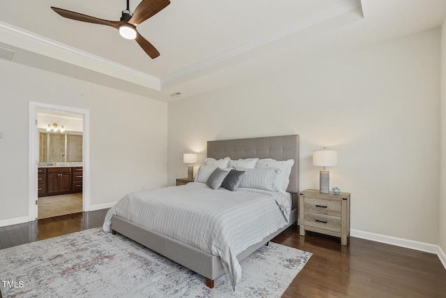 bedroom featuring crown molding, a raised ceiling, baseboards, and wood finished floors