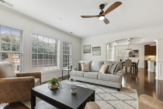 living area with visible vents, wood finished floors, crown molding, and ornate columns