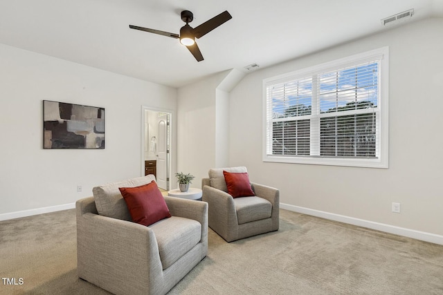 living area featuring visible vents, carpet floors, baseboards, and a ceiling fan