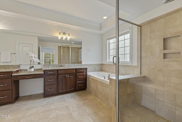 bathroom featuring a stall shower, vanity, a garden tub, and ornamental molding