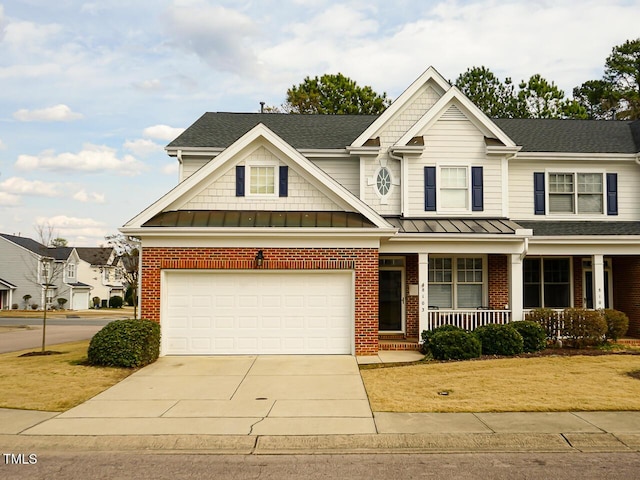 craftsman-style home with concrete driveway, brick siding, covered porch, and a standing seam roof