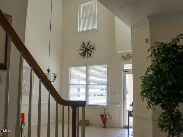 stairs with a high ceiling, baseboards, and crown molding