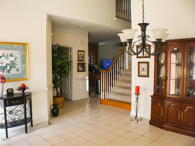 foyer entrance featuring light tile patterned floors, stairway, an inviting chandelier, ornamental molding, and baseboards