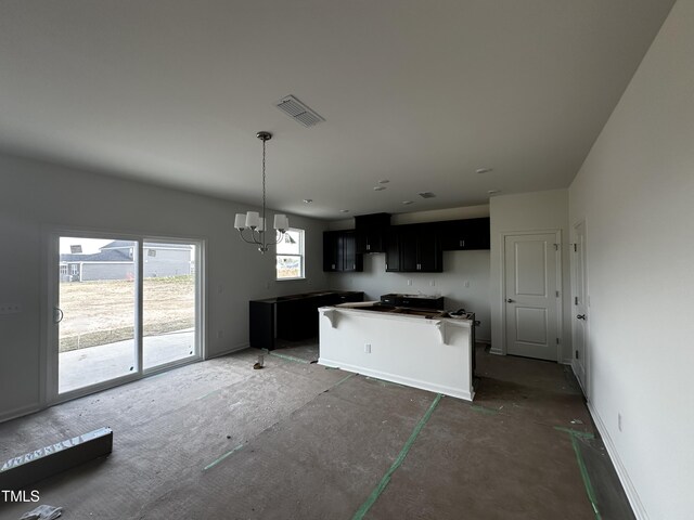 51 Robert Howe Dr, Fuquay Varina, NC 27526 - kitchen with dark cabinets, visible vents, a chandelier, baseboards, and a center island