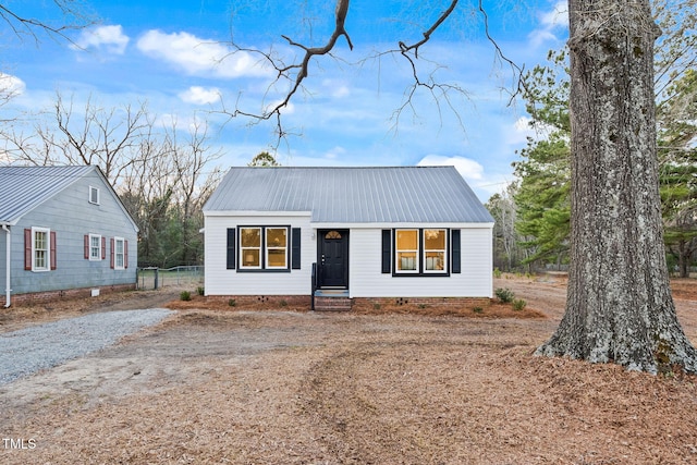 view of front of property with metal roof, driveway, and crawl space