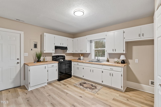 kitchen with under cabinet range hood, black range with electric stovetop, a sink, visible vents, and white cabinets