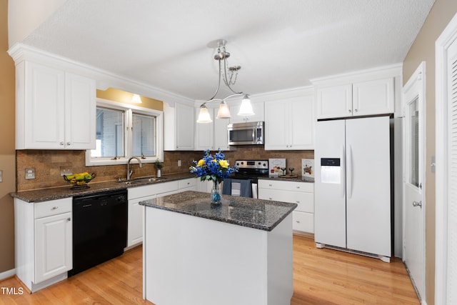 kitchen with a center island, stainless steel appliances, white cabinetry, a sink, and light wood-type flooring