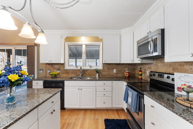 kitchen with tasteful backsplash, light wood-style flooring, stainless steel appliances, white cabinetry, and a sink