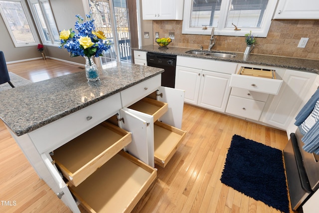 kitchen featuring a sink, white cabinets, black dishwasher, light wood-type flooring, and plenty of natural light