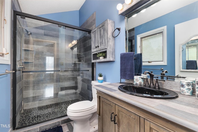 full bath featuring a stall shower, vanity, and toilet