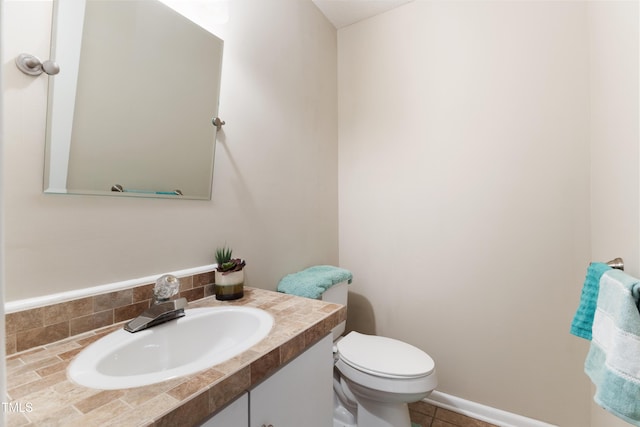 half bathroom with vanity, toilet, and tile patterned floors