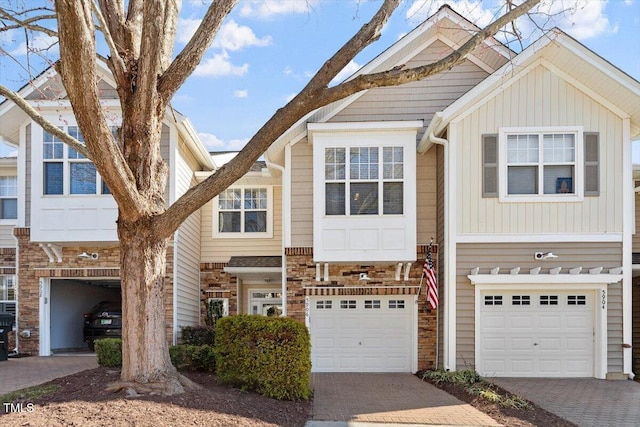 view of property with decorative driveway and a garage