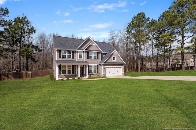 view of front facade featuring a porch, fence, driveway, stone siding, and a front yard