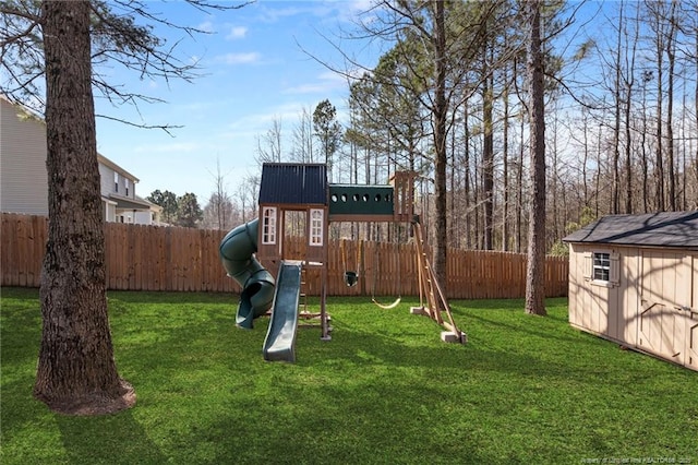 view of jungle gym featuring an outbuilding, a storage unit, a lawn, and a fenced backyard