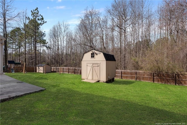 view of yard with a fenced backyard, an outdoor structure, and a shed