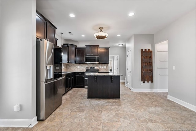 kitchen with light stone counters, a center island, visible vents, decorative backsplash, and appliances with stainless steel finishes