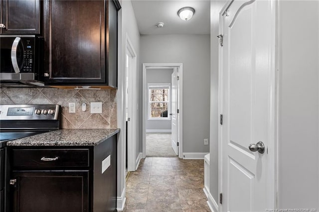 kitchen featuring stone countertops, baseboards, decorative backsplash, stainless steel appliances, and dark brown cabinets