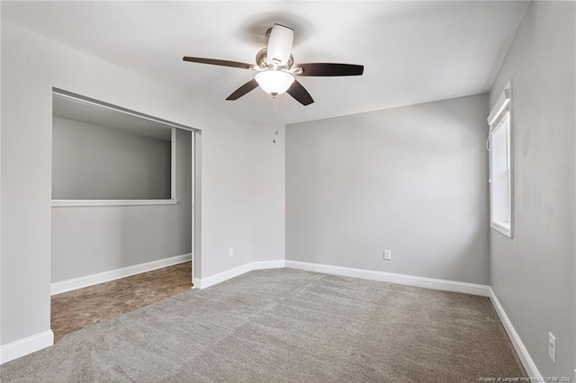 unfurnished bedroom with carpet floors, a ceiling fan, baseboards, and a closet