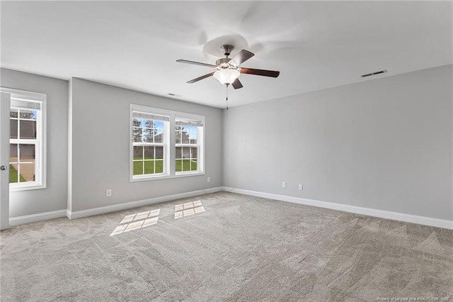 spare room with baseboards, carpet floors, visible vents, and a healthy amount of sunlight