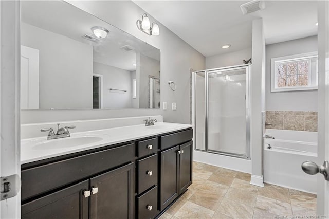 bathroom with double vanity, a stall shower, a sink, and visible vents