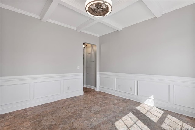 unfurnished room with beam ceiling, coffered ceiling, a wainscoted wall, stone finish floor, and a decorative wall