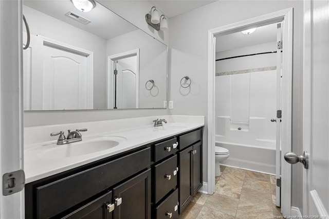 bathroom featuring double vanity, visible vents, toilet, and a sink