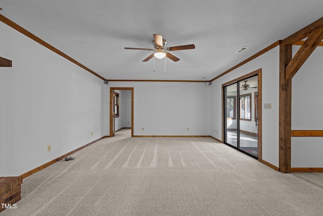 spare room with a textured ceiling, light carpet, visible vents, baseboards, and ornamental molding