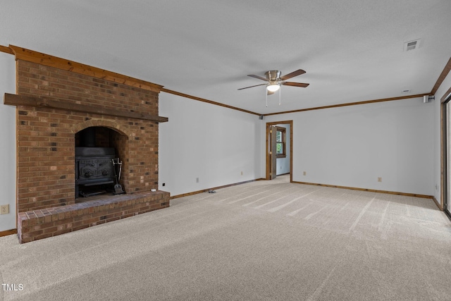 unfurnished living room with light colored carpet, a wood stove, visible vents, and baseboards