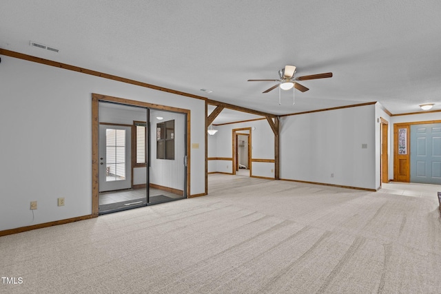 carpeted spare room with baseboards, visible vents, ornamental molding, and a textured ceiling