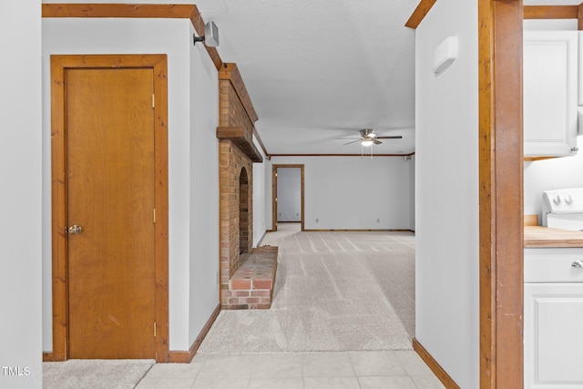 hallway featuring light carpet, light tile patterned flooring, and baseboards