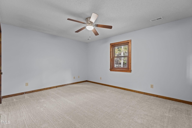 carpeted empty room featuring baseboards, visible vents, and a textured ceiling