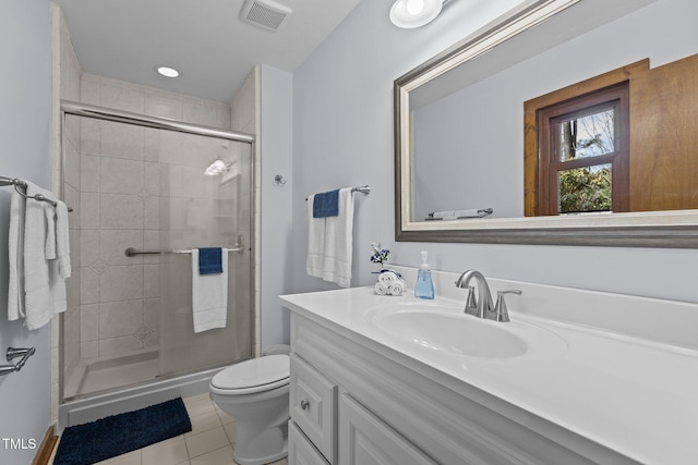 bathroom with visible vents, toilet, vanity, a shower stall, and tile patterned floors