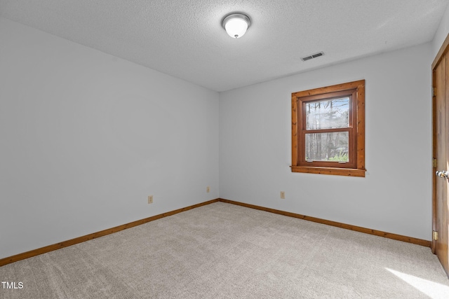 unfurnished room featuring carpet floors, visible vents, a textured ceiling, and baseboards