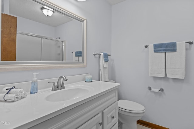 bathroom featuring toilet, a shower with door, baseboards, and vanity