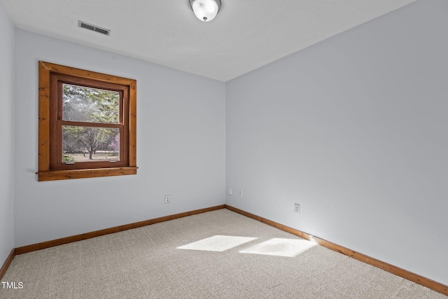 unfurnished room with carpet flooring, visible vents, and baseboards