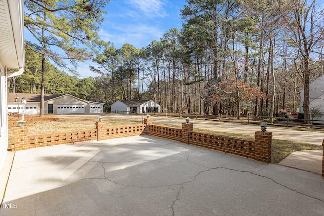 view of patio featuring fence and a detached garage