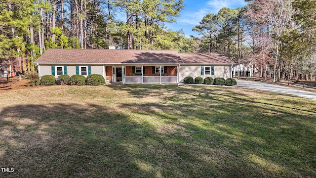 ranch-style home featuring a porch, brick siding, a chimney, and a front lawn